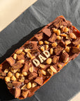 extra large reese's pieces caramel slice with "dad" written in white chocolate