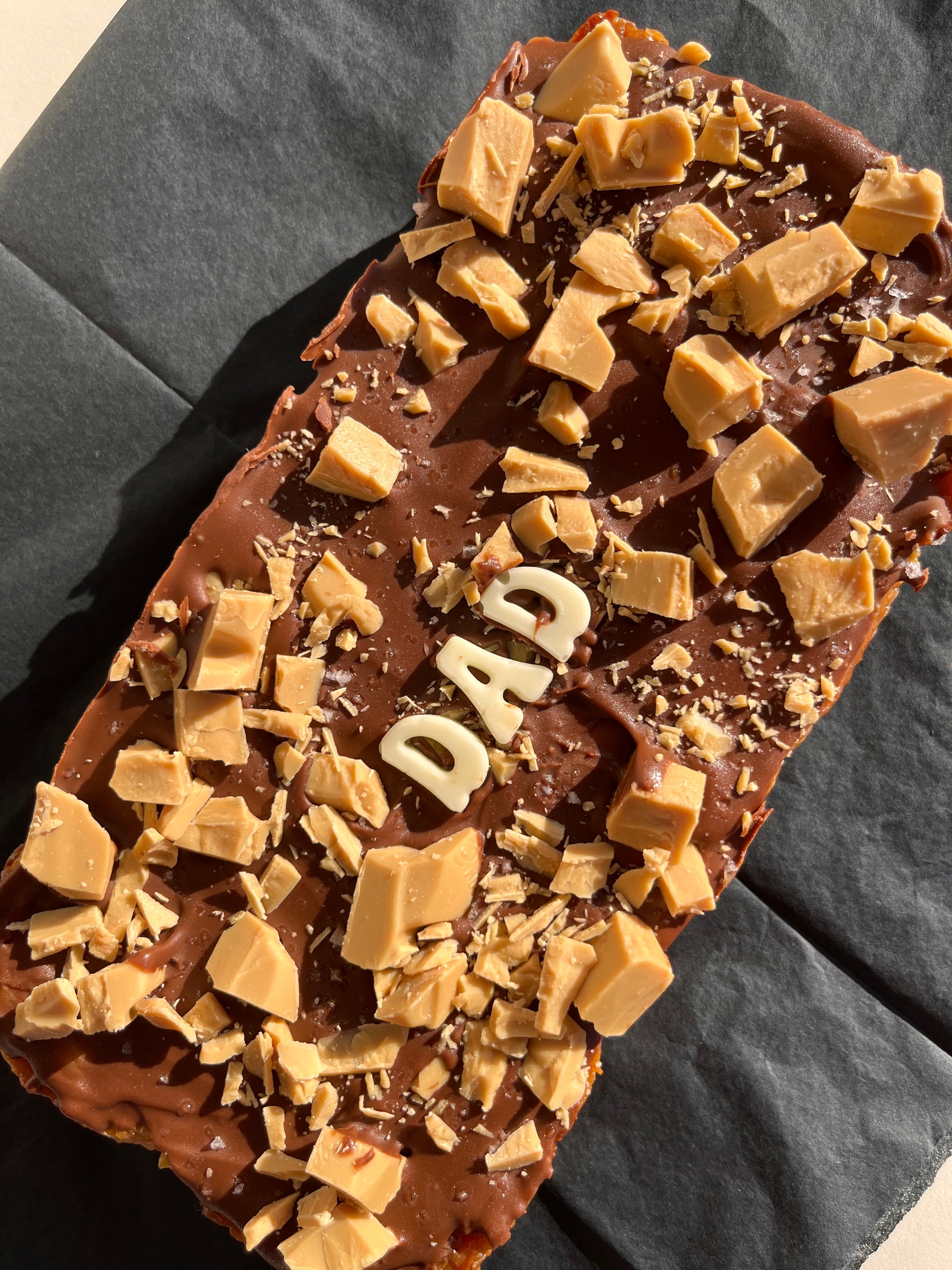 extra large Salted Caramilk caramel slice with &quot;dad&quot; written in white chocolate
