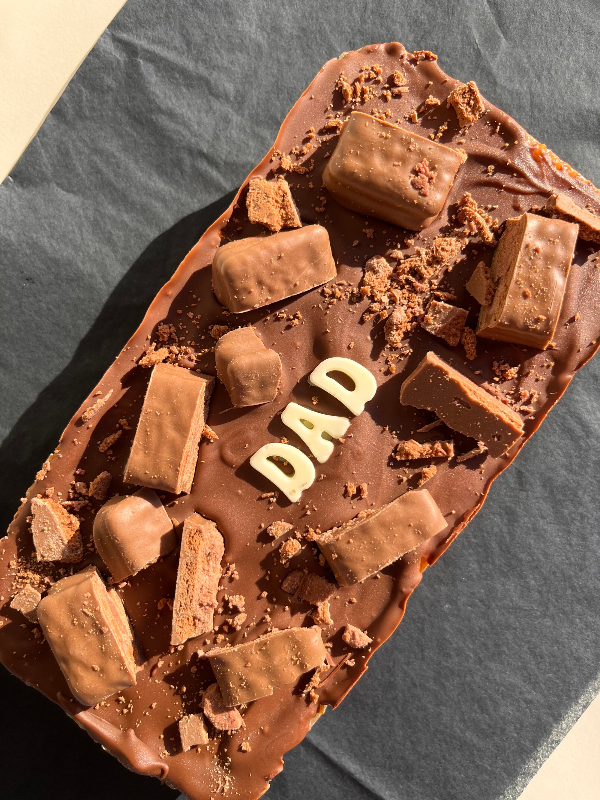 extra large Tim Tim caramel slice with &quot;dad&quot; written in white chocolate
